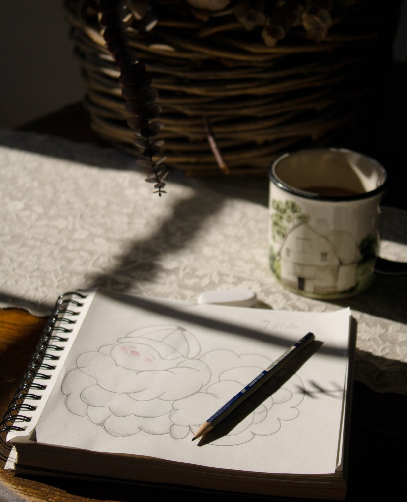 A vintage book, sketch book, and coffee cup arranged in warm morning sunlight.